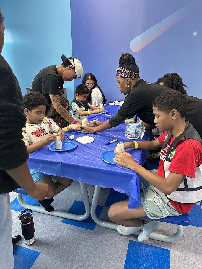 Party host helping children with a craft activity during a birthday party at Hyper Kidz Crofton